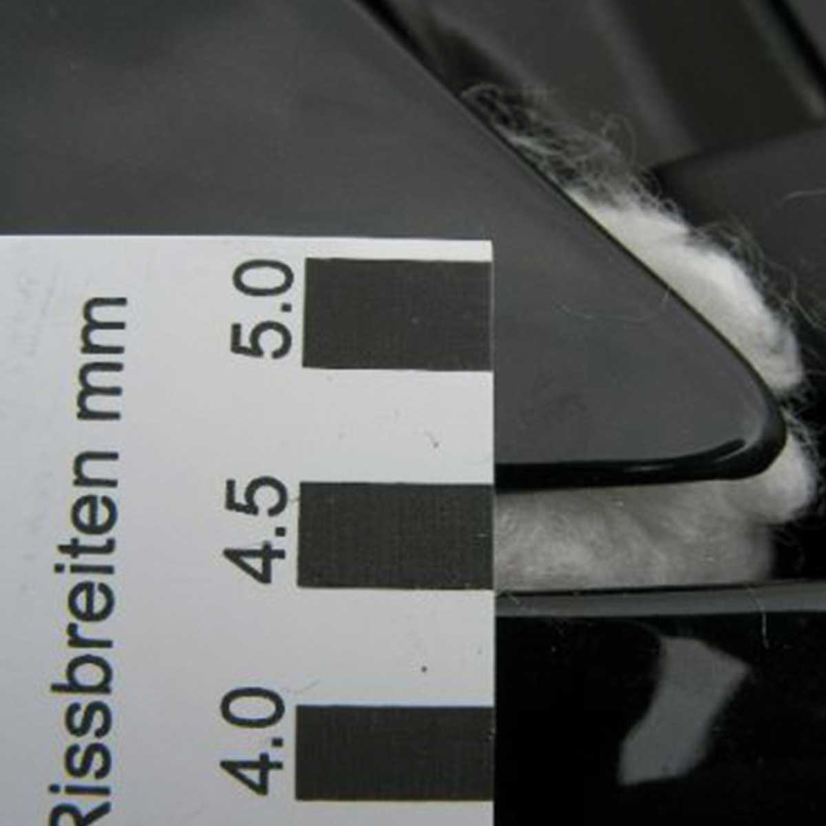 Risslineal an einem Spalt zur Ablesung der Rissbreite zwischen 4,0 und 5,0 mm.