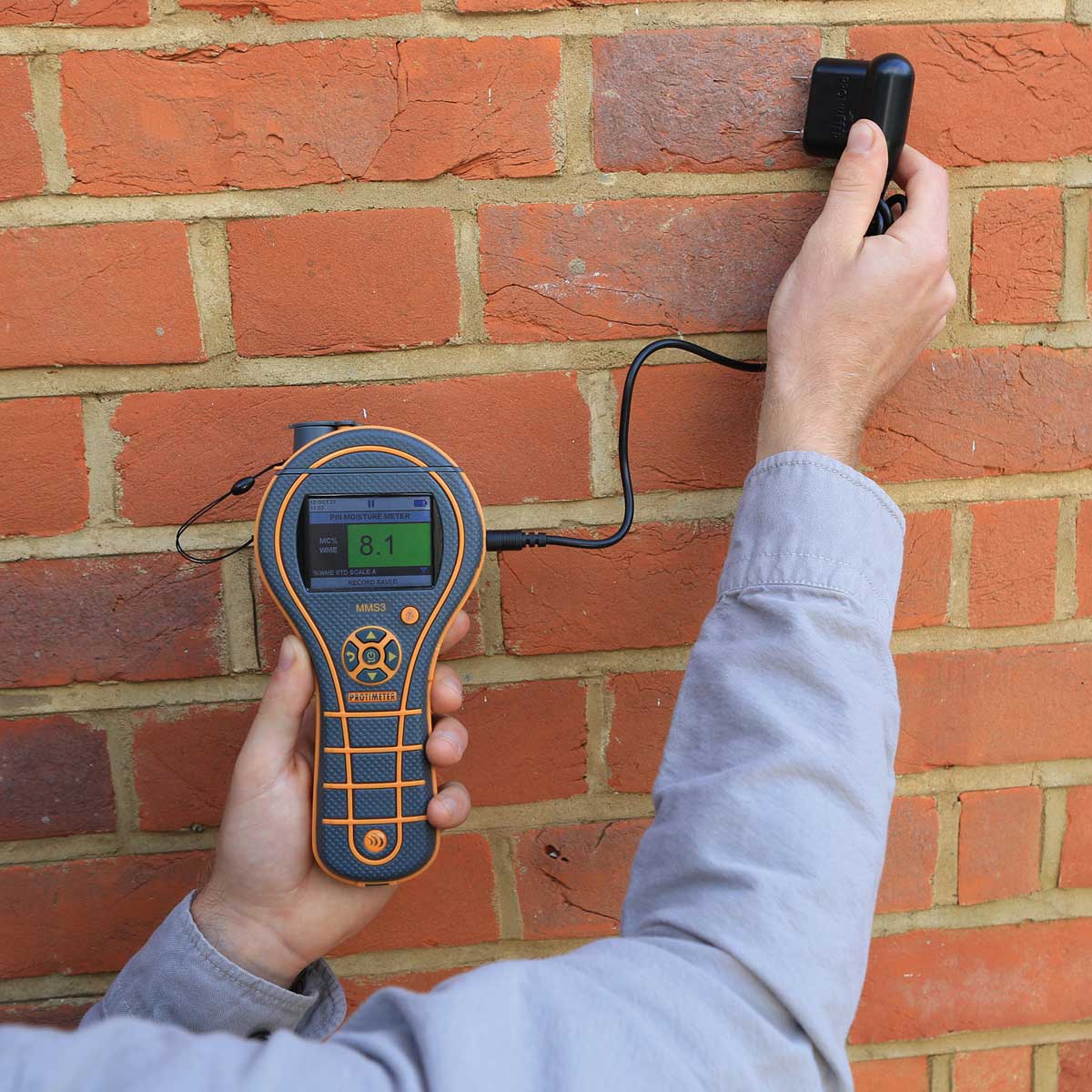 Protimeter MMS3 mit Einstechelektrode bei der Feuchtemessung an einer Ziegelwand.