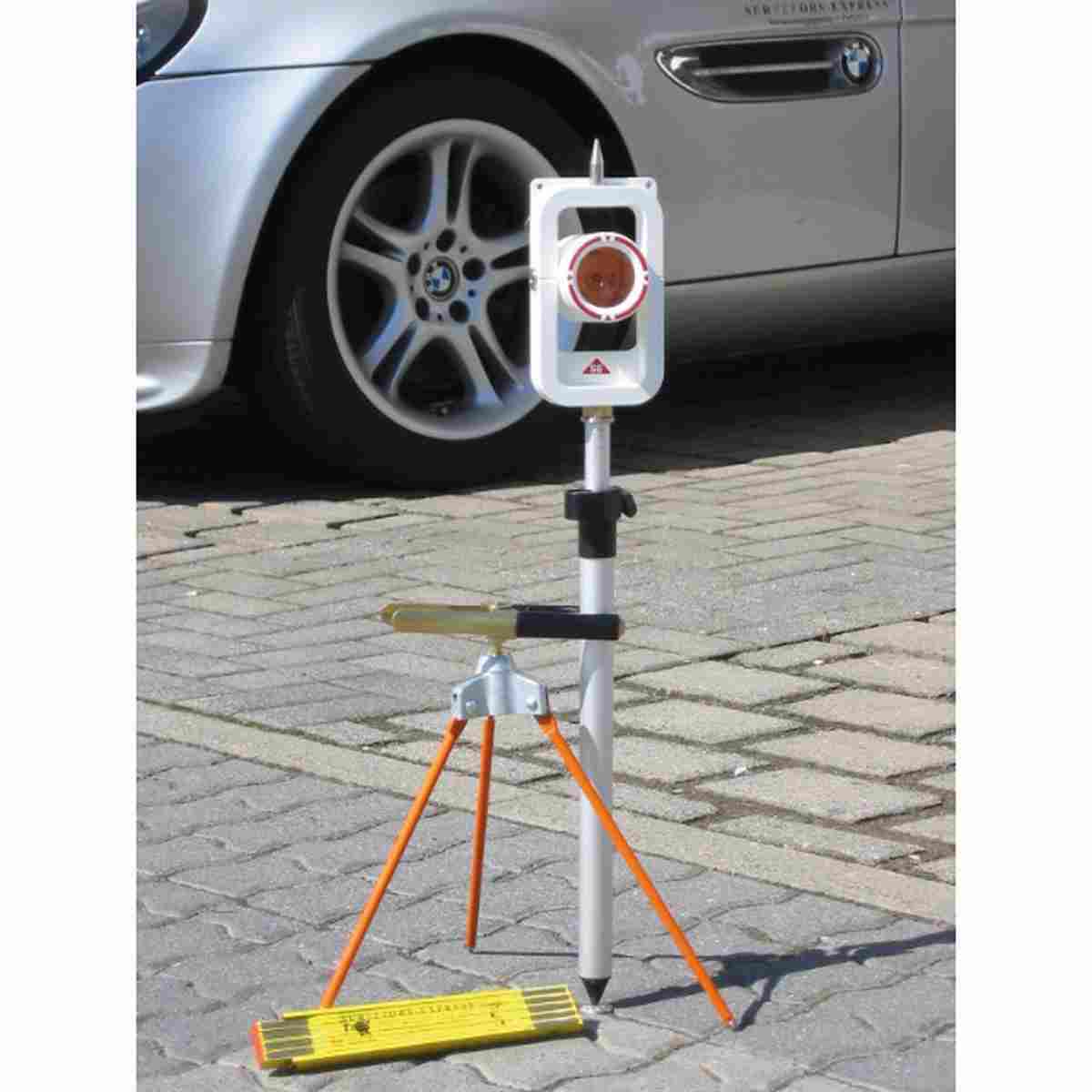 MIDI-Prismenstab mit weißem SE-Prisma und Stativstütze auf Pflaster vor einem Auto.