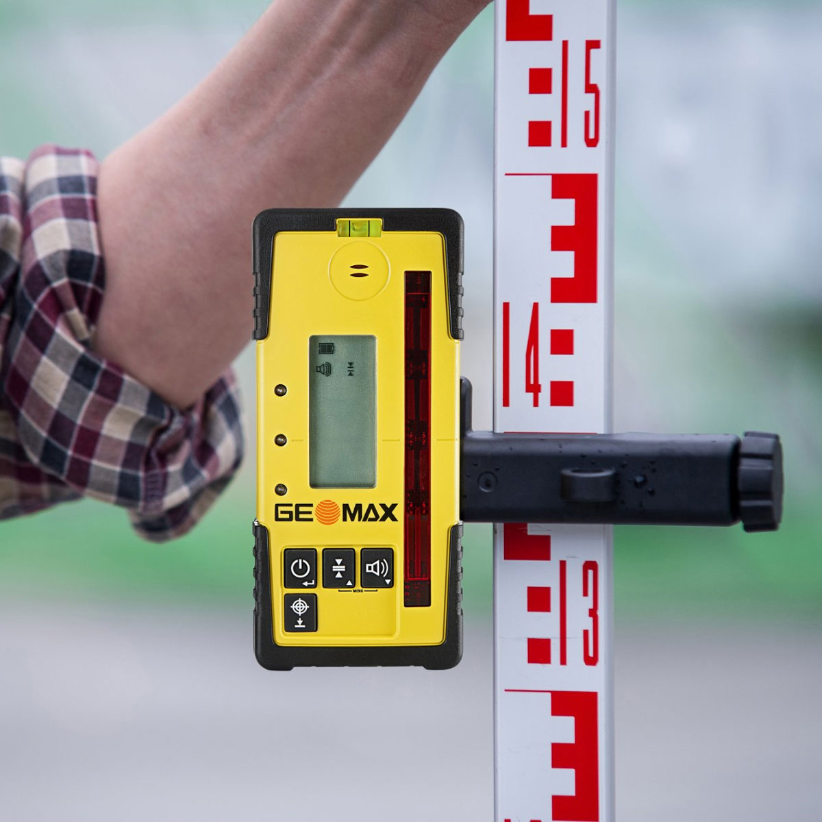 GeoMax Handempfänger ZRD105 mit Halterung im Einsatz an einer rot-weißen Nivellierlatte.