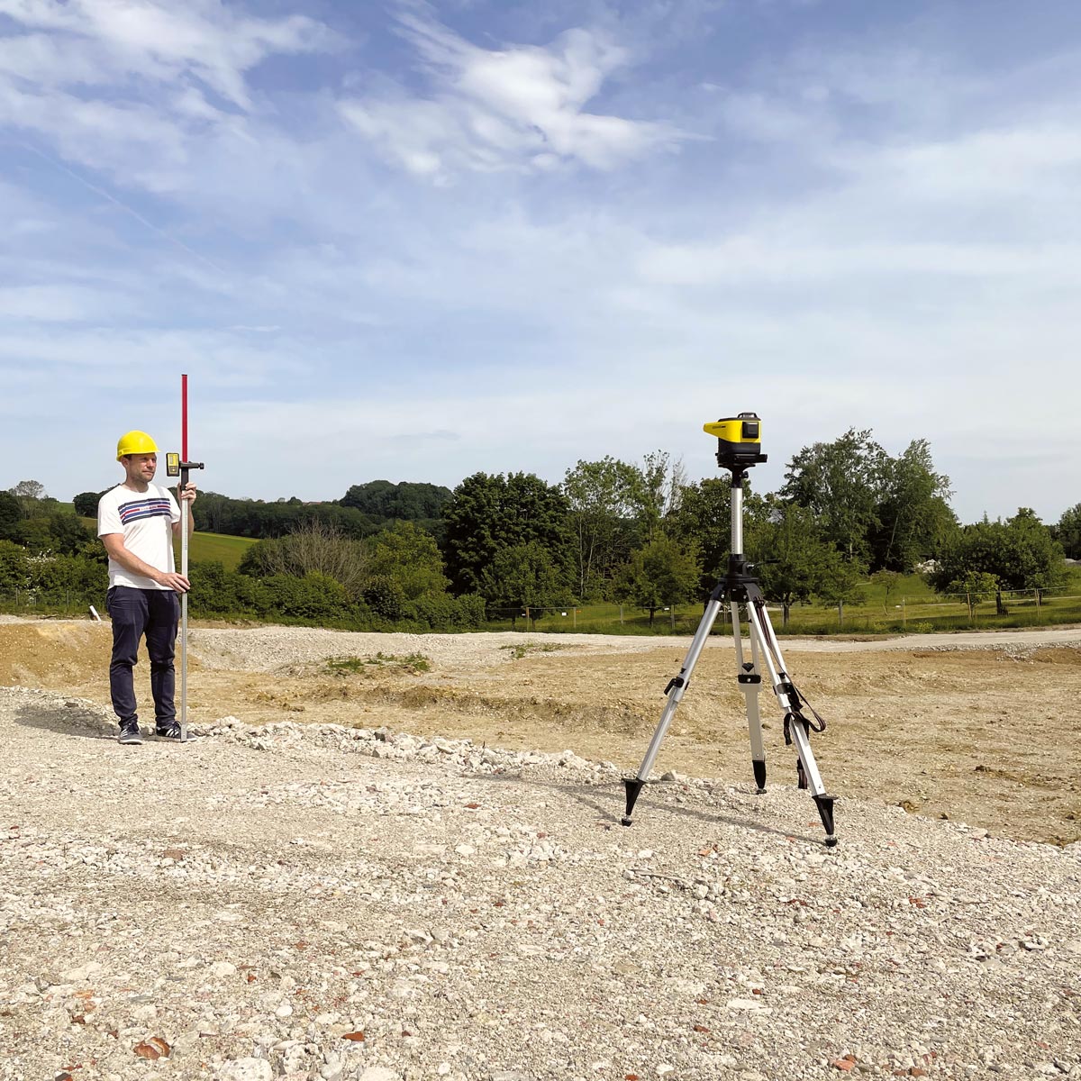 Vermesser nutzt den proNIVO Neigungslaser PNGLR-2D auf einem Stativ bei einer Geländevermessung auf einer Baustelle.