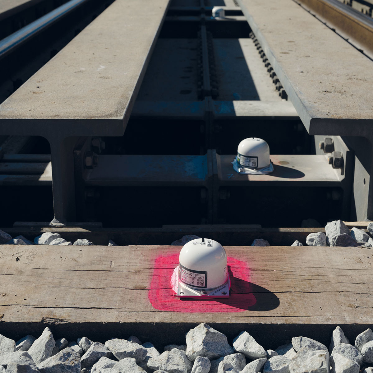 Der Senceive FlatMesh NanoPlus Sensor ist auf einer Schiene befestigt und überwacht Gleisbewegungen.