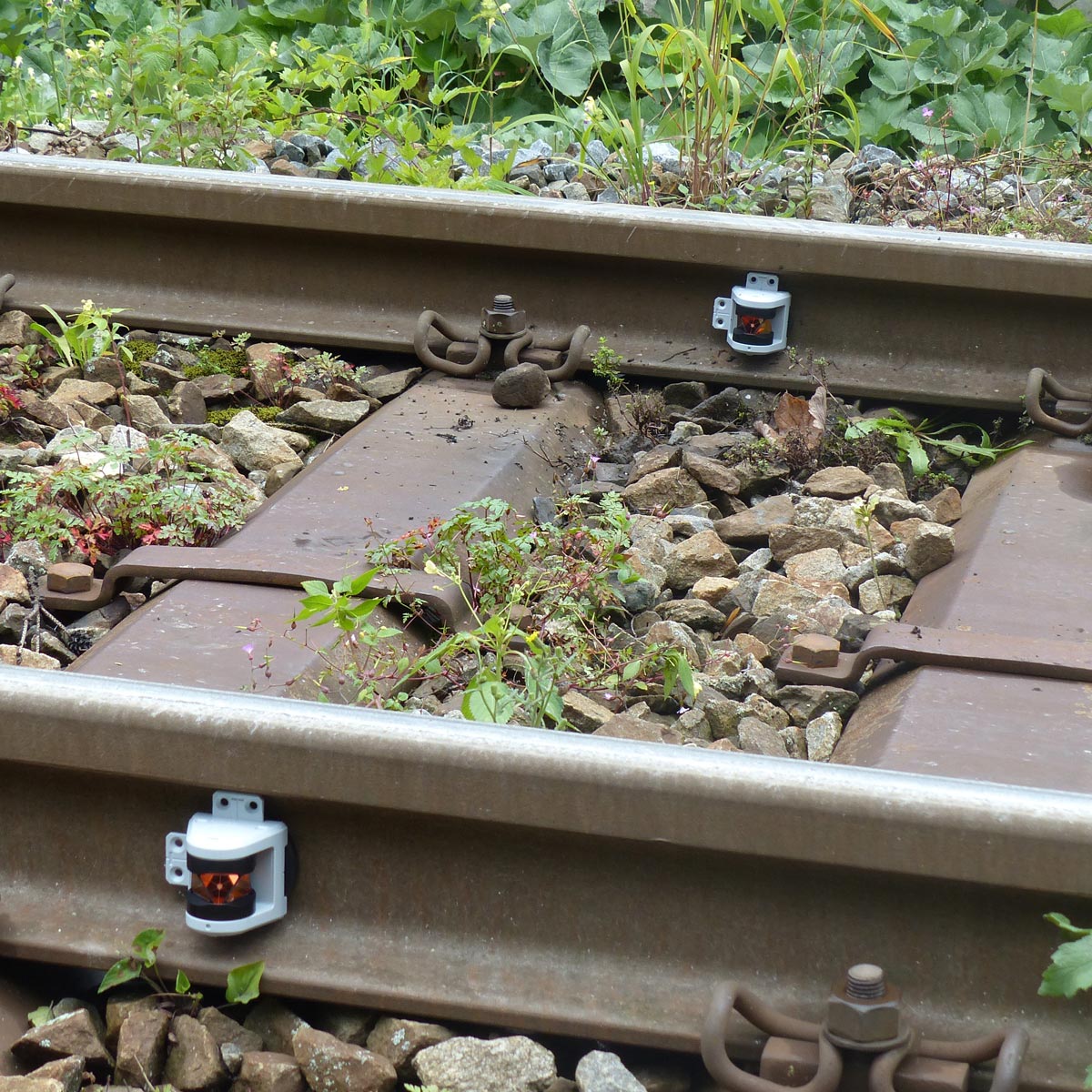 Zwei magnetische RSMP480 Prismen von Rothbucher zur Überwachung von Gleisbewegungen im Schotterbett.