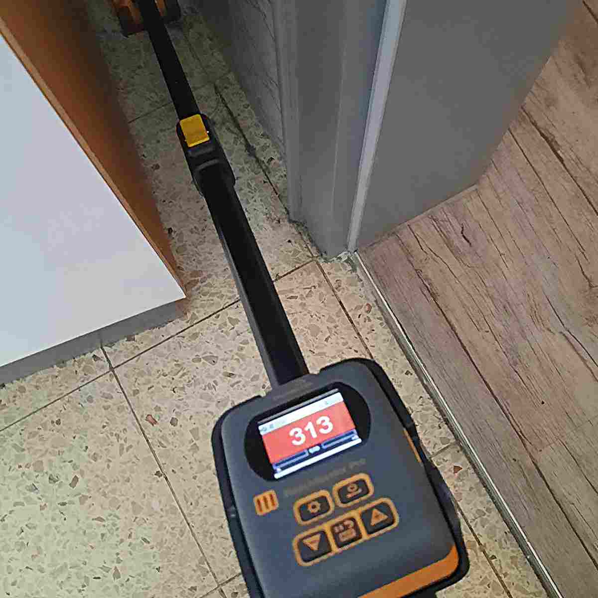 Protimeter Reachmaster Pro misst Feuchtigkeit am Boden, Display zeigt roten Messwert 313.