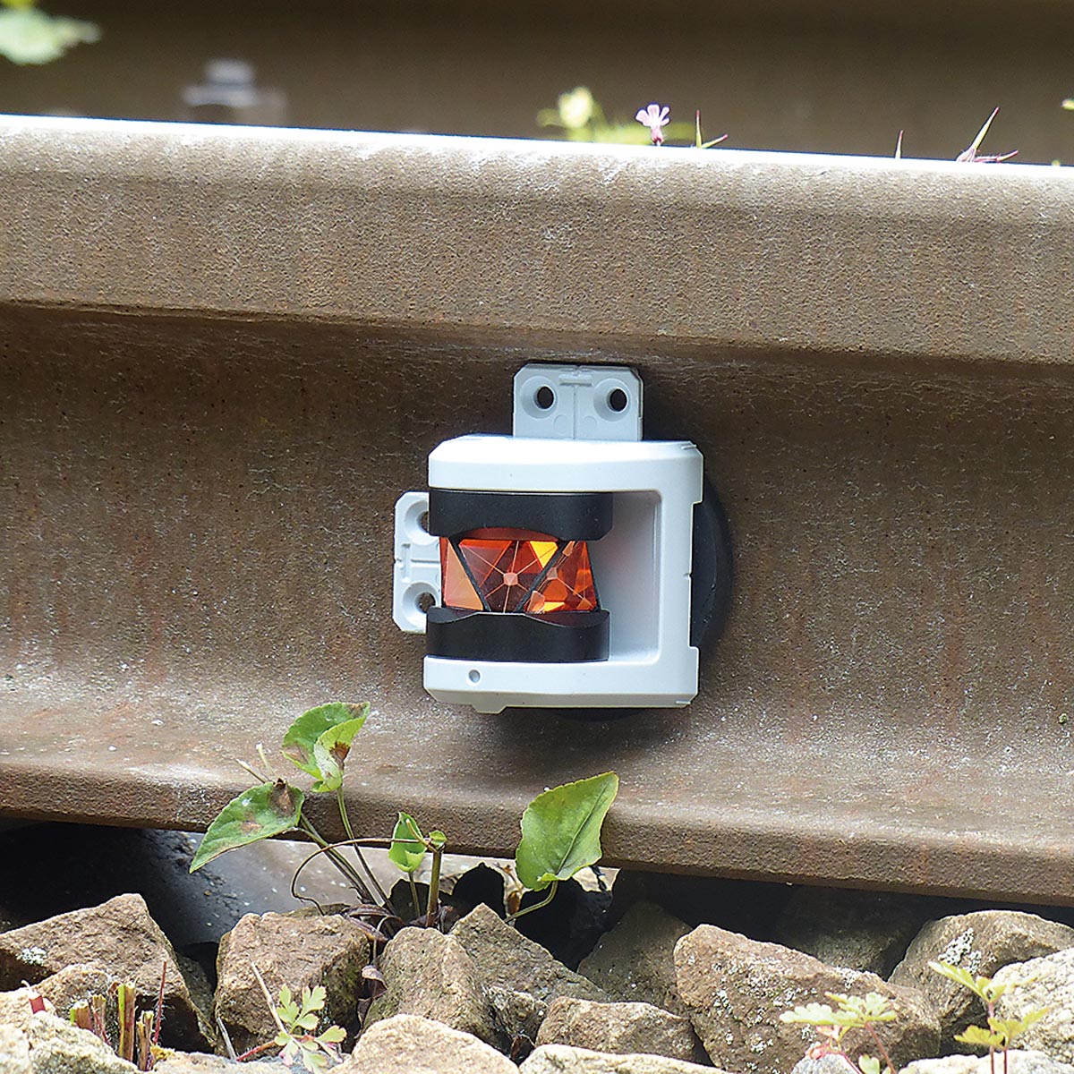 Nahaufnahme des Rothbucher RSMP480 Prismas, magnetisch an einer Gleisschiene befestigt.