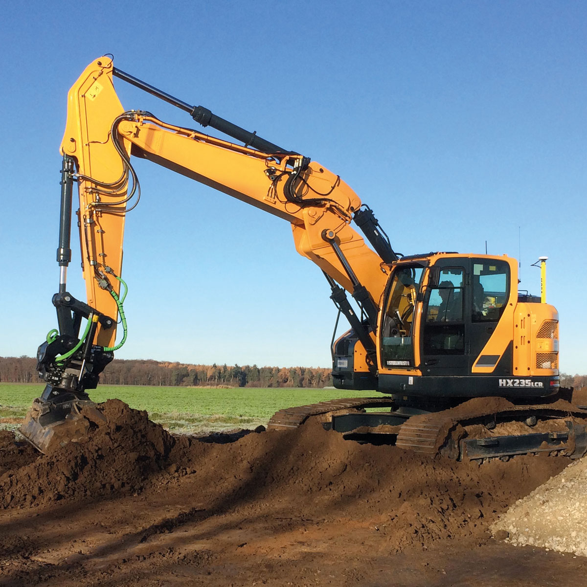 Hyundai Bagger HX235LCR mit MOBA Maschinensteuerung beim Erdaushub auf einem Feld.
